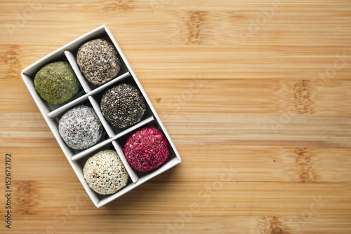 Vegan raw sweet balls on a wooden background. Sugar-free and gluten-free sweets.