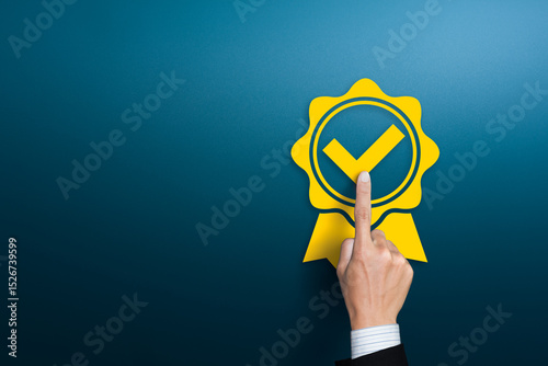 Businessman pushing rosetted award medal with check mark tick label, approved check mark ribbon, concept of premium quality or recommended certificate icon, Guaranty or warranty badge, copy space