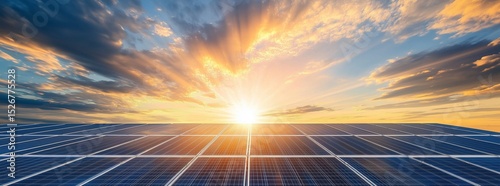 Wide shot of solar panels under blue sky with sun rays and clouds

