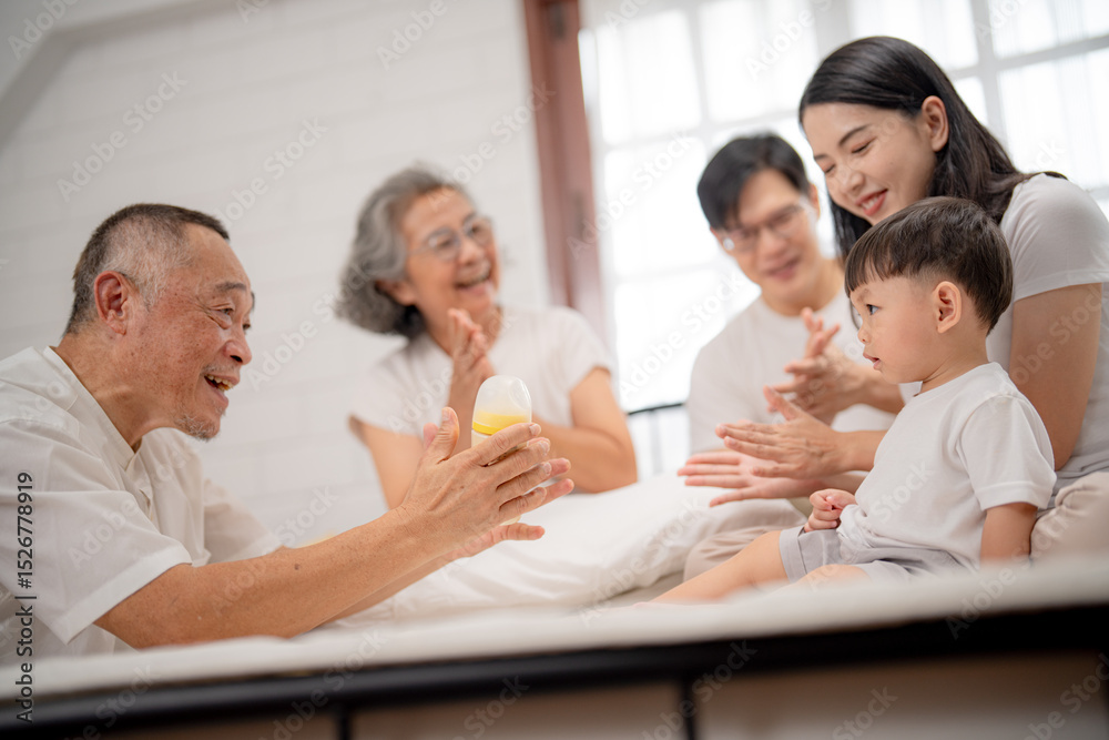 Obraz premium Family gathering with grandparents and child enjoying quality time in a cozy indoor setting