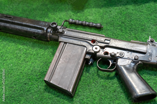 Vintage battle rifle on green surface