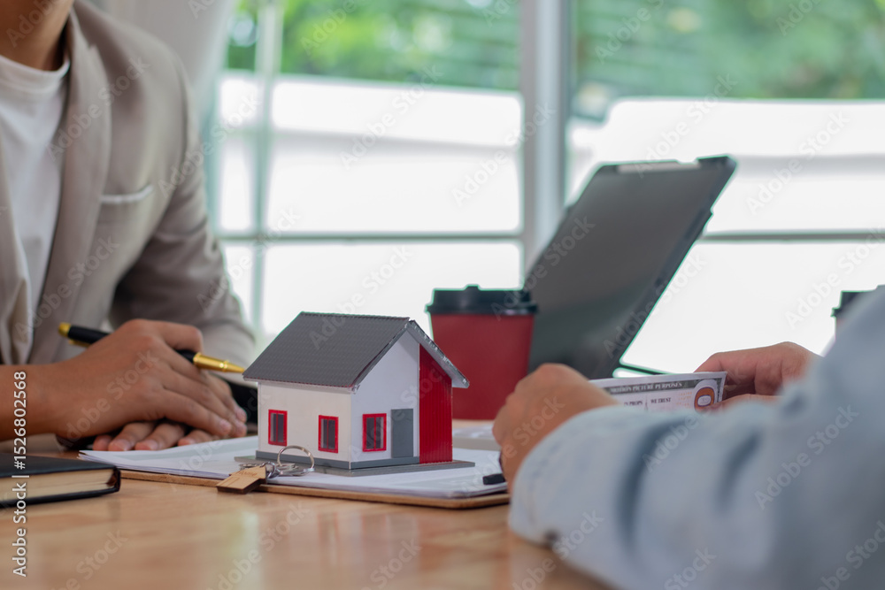 Fototapeta premium Middle-aged male real estate agent in office analyzes housing documents, signs apartment sale contract, discusses loans, investments, mortgages and property deals with clients.