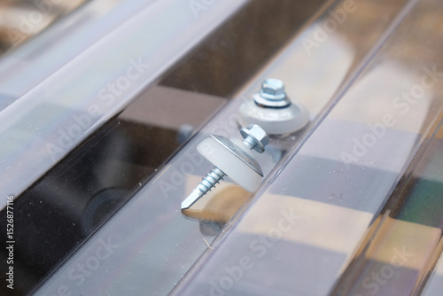 Thermal washer and self-tapping screw - fastener for profiled polycarbonate, close-up.