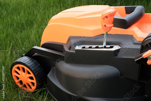 Detail of an electric lawn mower - close-up of the cutting height control lever.