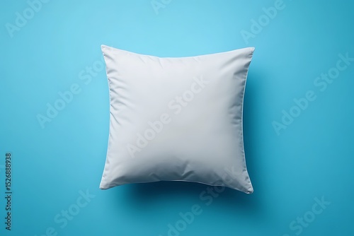 White pillow isolated on blue background. Flat lay, top view.