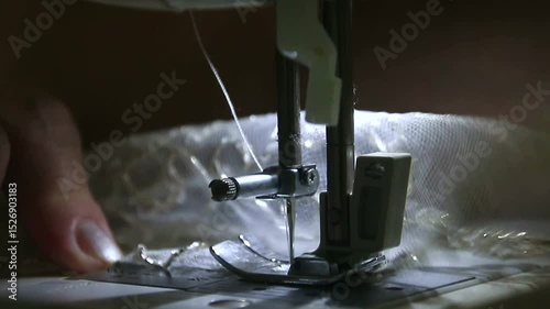 Sewing machine with needle stitches fabric in macro