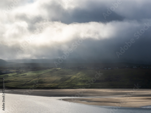 Mist-covered hills in the Scottish highlands with beach and dramatic clouds, Sutherland, Scotland