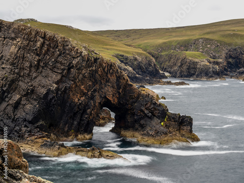 Rugged rocky coast with stone arch in Sutherland, Scotland
