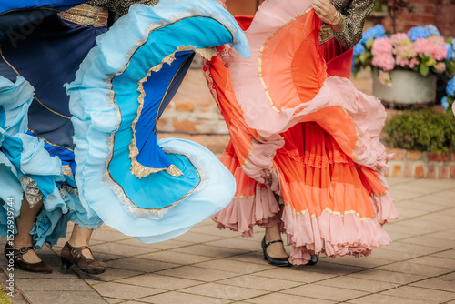 Photography Close-up of dancers in traditional, colorful layered skirts during a lively folk performance, highlighting motion and ornate costume details