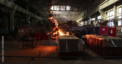 The molten metal is poured into the mold. Melting furnace for cast iron and steel and liquid metal. photo