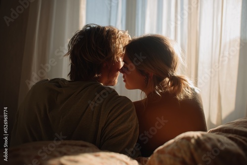 Romantic couple in soft morning light sharing an intimate moment near a window with warm natural tones. Perfect for themes of love, connection, and peaceful domestic life.