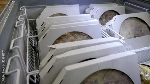 Delicious frozen pizzas in the freezer in boxes	
