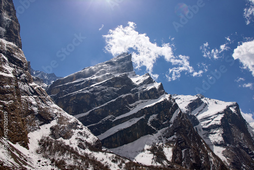 Wallpaper Mural Snow-covered mountains rise dramatically against a vibrant blue sky in the Annapurna region. This breathtaking view captures the essence of trekking in Nepal's majestic landscape Torontodigital.ca