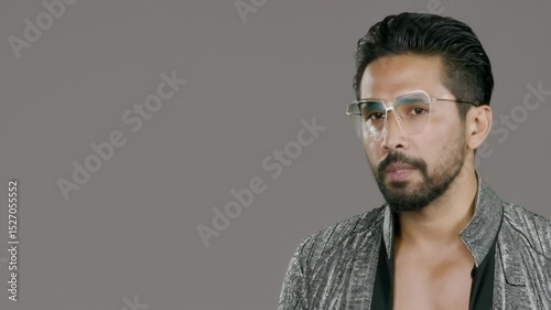 Celebrity man in glasess discusses personal journey and creative process while showcasing unique fashion style in a studio setting
