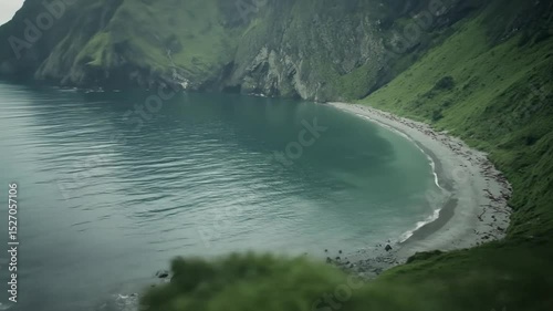 Wallpaper Mural Picturesque cove nestled within rugged mountains overlooking a tranquil beach. Lush green hills and dark cliffs meet the serene, teal colored water.  Small beach area visible Torontodigital.ca