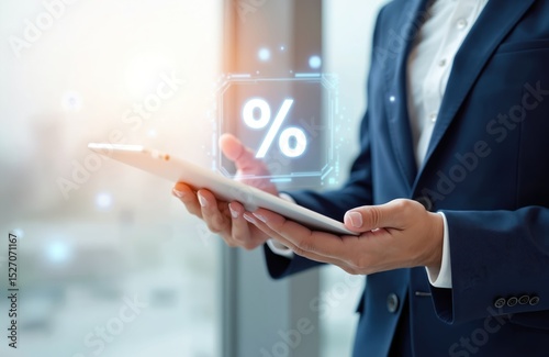Businessman holds tablet displaying digital hologram percent sign. Interest rate, financial, ranking, mortgage rates concept. Discount commission, promotion, price reduction presented. Economy,