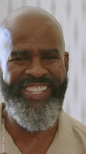 Vertical video: Senior African American man smiling laughing and speaking engaging viewer in studio