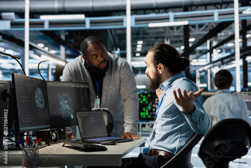 Data center manager berating employee during intense discussion, reproaching performance issues. Technician in server hub receiving verbal reprimand from upset management team leader
