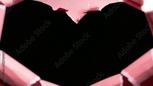 Tearing heart-shaped hole frame on pink paper, abstract video footage background










