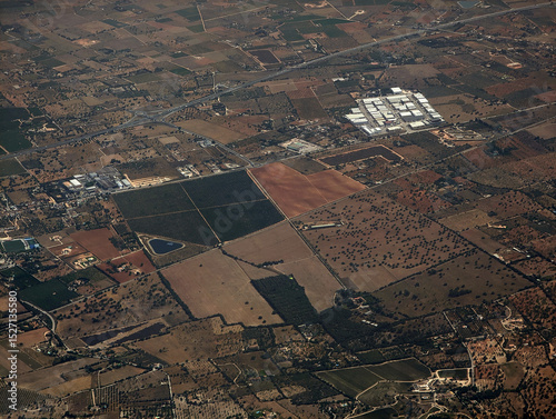 Aerial view of Mallorca, Es Raiguer region lands. Santa Maria del Camí cultivation plots and industrial estate, Consell farmlands and flea market, Alaró rustic finca property houses, Ma-13 highway. 