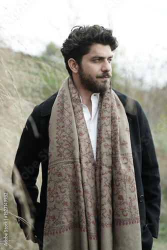 A Kashmiri model dressed in a traditional shawl and vintage-style pheran, posing for a Kaar Kash shoot that highlights timeless craftsmanship and the cultural soul of Kashmir.

