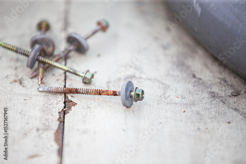 Screws and dowels on a wooden background. Selective focus.
