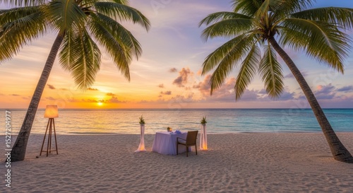Romantic dining table setting on tropical beach at sunset.
