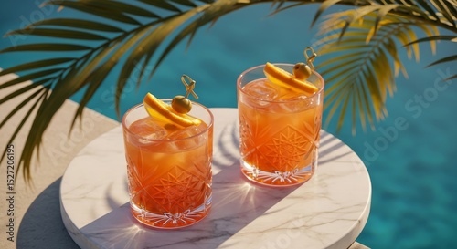 Two vibrant cocktails with orange and olives on marble table