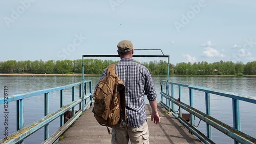 traveler walking on pier with backpack