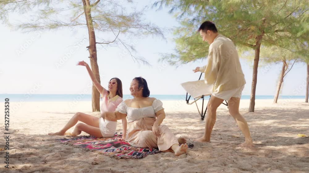 Happy Asian man and woman travel the sea on summer beach holiday vacation. Group of People friends enjoy and fun outdoor lifestyle picnic, playing guitar and dancing together on the beach in sunny day