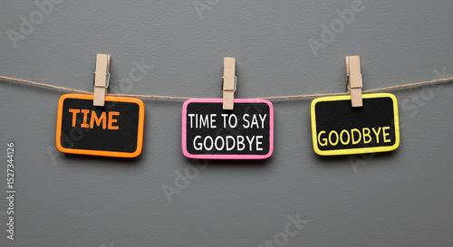 Three signs hanging from a string with clothespins displaying the words time to say goodbye business ,technology ,selling ,purchasing ,agreement ,$