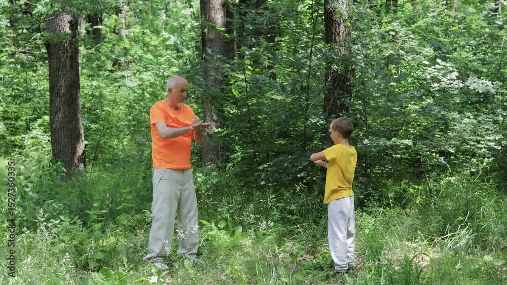 Little boy and old man making blocks with their hands against a nature background Little boy and old man making blocks with their hands against a nature background