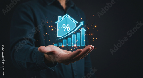 A hand holding a glowing blue house icon with a percentage sign and a rising bar graph with arrows business.selling ,purchasing,agreement 