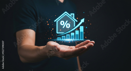 A hand holding a glowing house icon with a percentage sign and an upward trending bar graph overlayed business.selling ,purchasing,agreement 