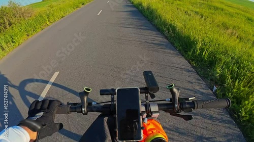 man riding bike at sunset outside city and filming video for blog, solo bike trip