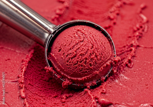 Red ice cream scoop presents a frosty treat Its smooth texture tempting indulgence Sweet delight