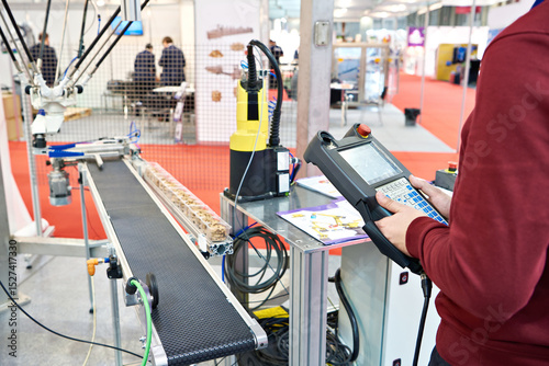 Photos Worker with control panels for manipulators for food production