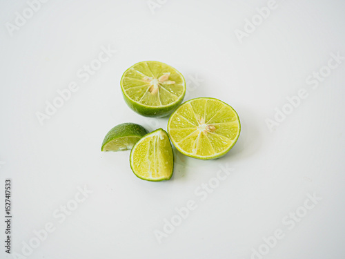  Close-up of green limes with leafy garnish and half-sliced detail perfect for food menu designs and tropical ingredient branding in culinary media