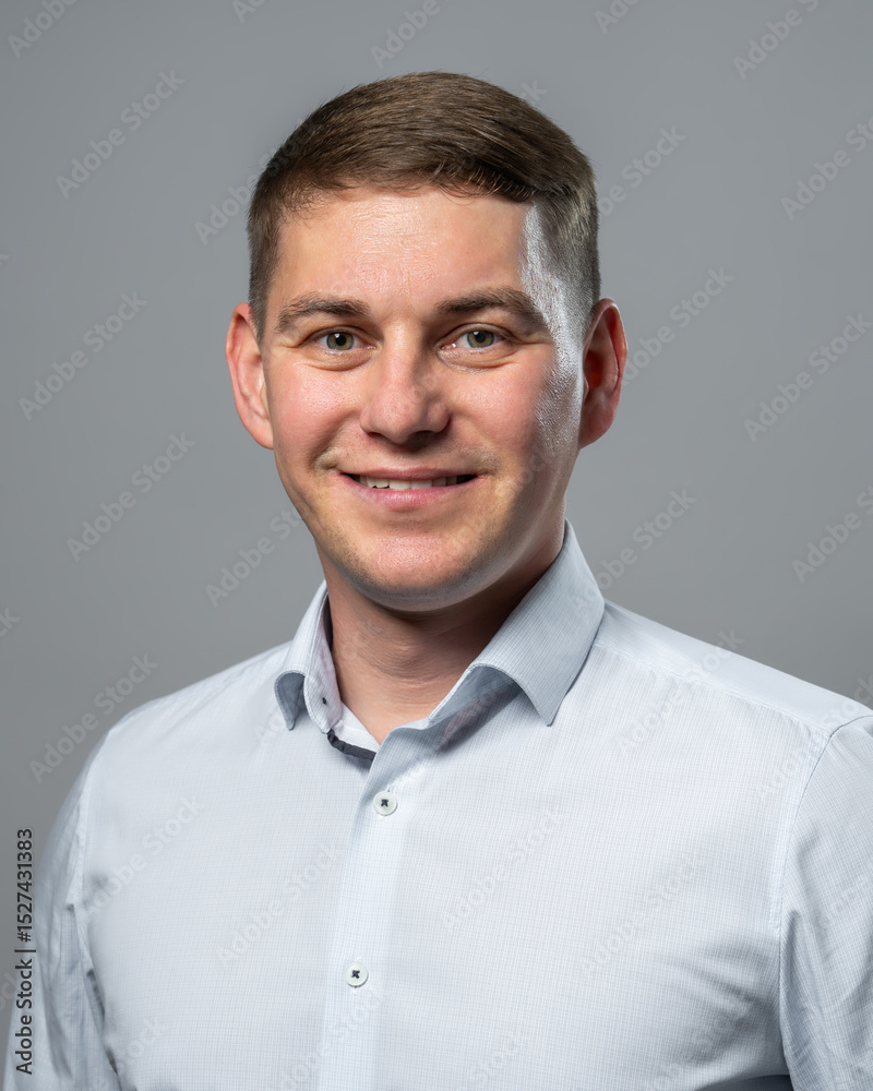 Studio shot of young man wearing classic white dress shirt, looking directly at camera. Concept of confidence, business, fashion, or lifestyle themes. Studio shot of young man wearing classic white dress shirt, looking directly at camera. Concept of confidence, business, fashion, or lifestyle themes.