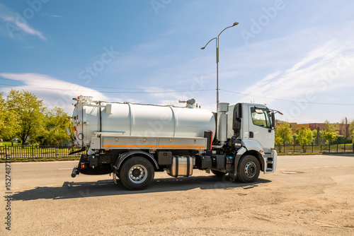 Modern vacuum sewage truck parked on a city street on a sunny spring day