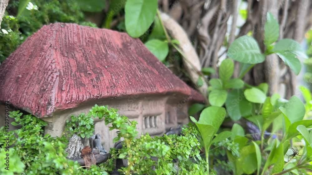 Vietnam, Nha Trang - 04.05.2025 - small cosy house in greenery, life in the forest, brown roof, light walls, toy house, Hut in the forest. Building layout, garden decor