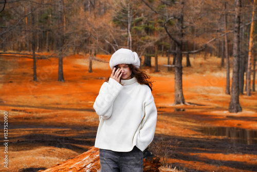 A smiling female traveler enjoys the beautiful scenery of the autumn forest. Travel, adventure. Concept of an active lifestyle.