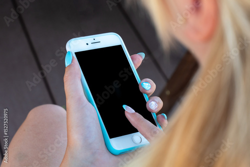 Woman is holding a phone with a blue case and a black screen