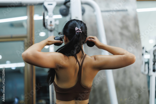 Woman doing pec deck fly exercise in gym for strong pectoral muscles