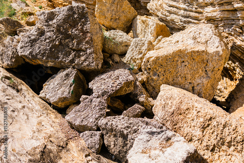 Broken limestone blocks scattered across a rocky slope. Natural erosion, geology, and raw mineral texture in an outdoor setting.