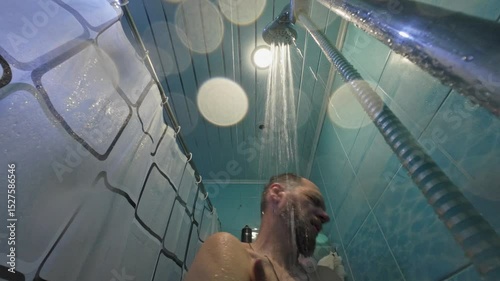 bearded middle aged man washing himself under shower in bathroom, hygiene and body care