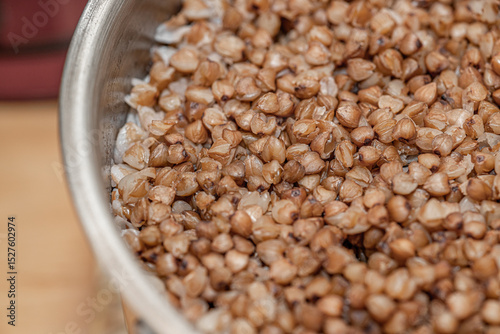 Plate with tasty buckwheat porridg.Boiled buckwheat porridge in ceramic pot on wooden background.
