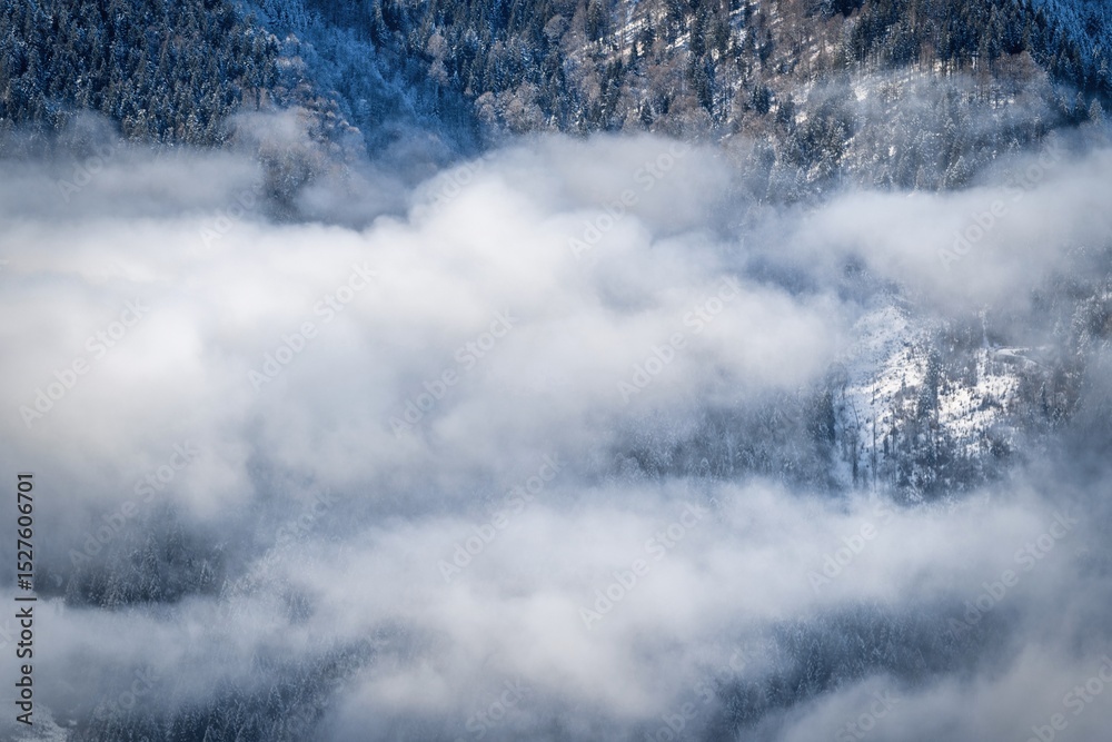 Obraz premium winter mountain landscape with snow, fog and cloud covered areas