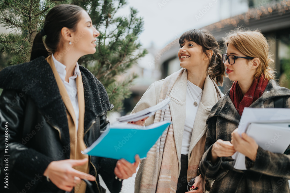 Three young businesswomen in stylish outfits conversing outdoors, representing teamwork and camaraderie. Three young businesswomen in stylish outfits conversing outdoors, representing teamwork and camaraderie.