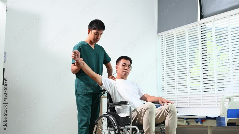 Asian physiotherapist helps senior patient on wheelchair with arm exercises during stroke recovery. Elderly care, rehabilitation Asian physiotherapist helps senior patient on wheelchair with arm exercises during stroke recovery. Elderly care, rehabilitation